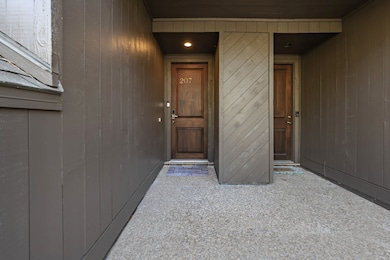 Well-lit entryway featuring a stylish wooden door
