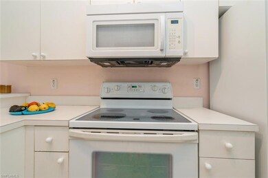 Kitchen featuring white cabinets and white applian