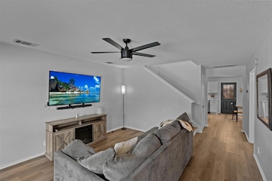 Living area with wood finished floors, ceiling fa