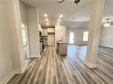 Kitchen featuring a kitchen island with sink, open floor plan, recessed lighting, a kitchen breakfast bar, and light wood-style flooring