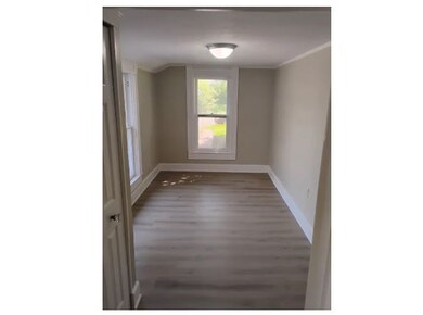 Empty room featuring dark wood-type flooring and ornamental molding
