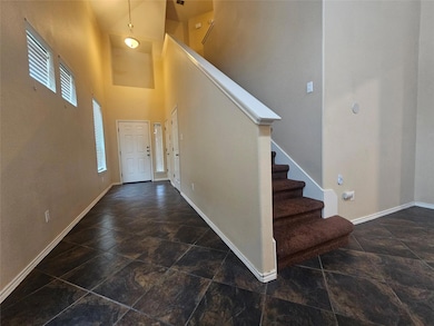 Entryway featuring stairs, a towering ceiling, an