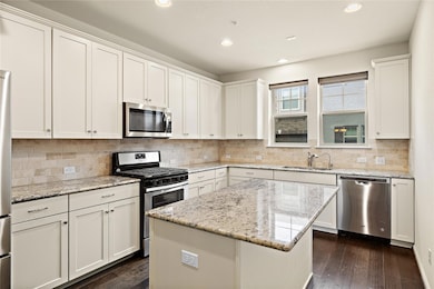 Kitchen featuring a sink, dark wood-style floorin