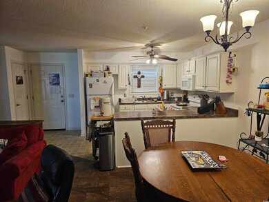 Kitchen with sink, white appliances, dark tile pat