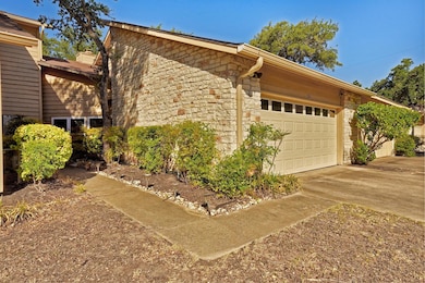View of home's exterior with driveway, stone sidi