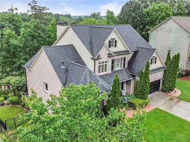 View of front of home featuring a shingled roof, a chimney, driveway, an attached garage, and brick siding
