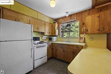 Kitchen with dark tile flooring, sink, and white appliances