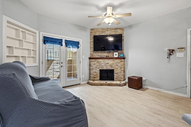 Living room with ceiling fan, baseboards, wood fin