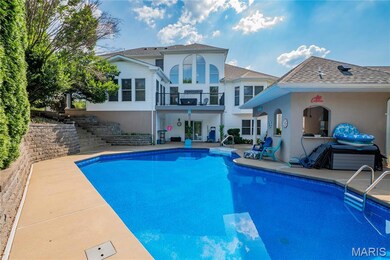 Rear view of house with stairs, a patio, an outdoor pool, and stucco siding