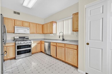Kitchen with a sink, visible vents, light countert