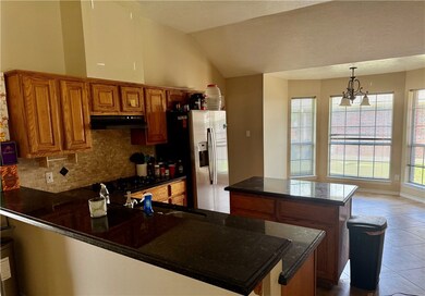 Kitchen featuring under cabinet range hood, brown