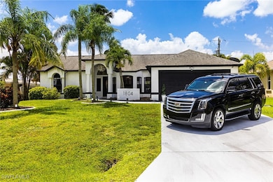 View of front of house featuring driveway, an atta
