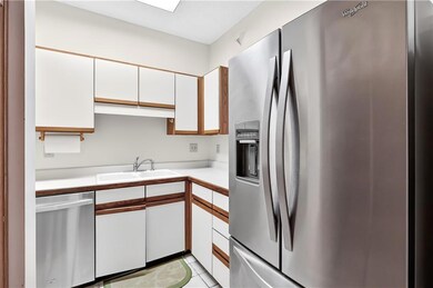 Kitchen featuring appliances with stainless steel finishes, white cabinetry, and light countertops