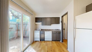 Kitchen featuring white appliances, light wood fin