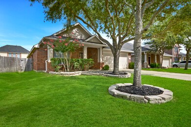 Another view of the beautifully landscaped front yard. This home offers a front porch with plenty of space for seating.