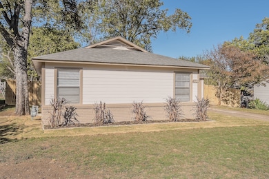 View of side of property with a shingled roof