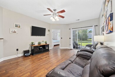 Living room featuring ceiling fan and dark hardwoo