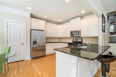 Kitchen with a sink, light wood-style floors, whit