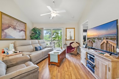 Living room with lofted ceiling, a ceiling fan, an