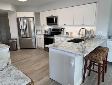 Kitchen featuring light stone countertops, a penin