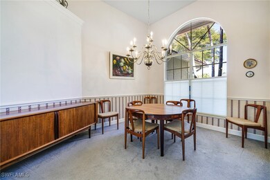 Carpeted dining space with a notable chandelier an