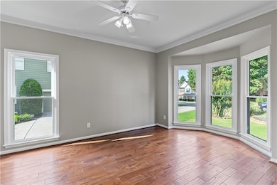 Plenty of natural light, crown molding, wood finished floors, and ceiling fan
