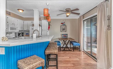 Kitchen featuring white appliances, tile counters,