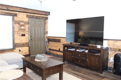 Living room featuring a wainscoted wall, wood fini