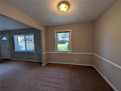 Spare room with visible vents, carpet floors, and 