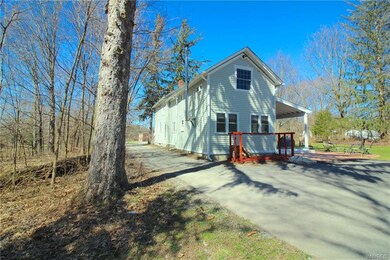 Rear view of house.  Trees on both sides and in ba