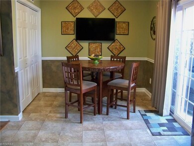 Kitchen and dining area are flooded with natural light from the patio doors and window over the sink...
