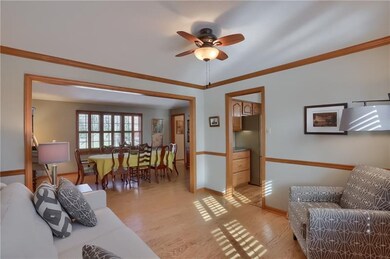 The living room boasts a chair rail, crown molding, bright windows and is accessible to the chef's kitchen.