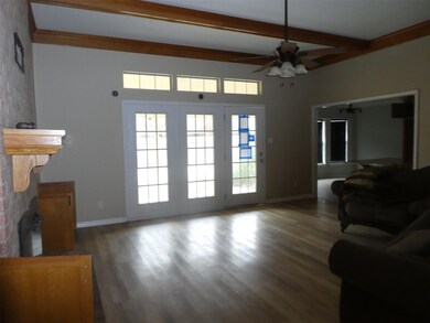 Living room featuring beam ceiling, a fireplace, c