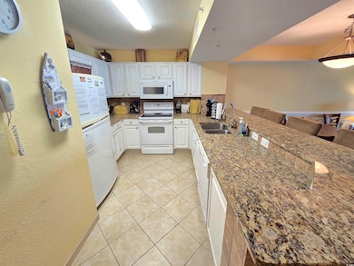 Kitchen with backsplash, white appliances, sink, a