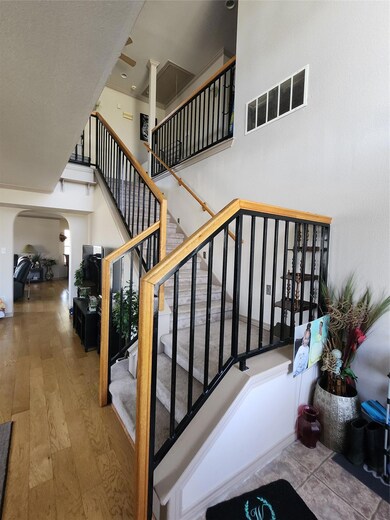 Stairway featuring wood-type flooring, a towering