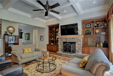 Large great room with coffered ceiling, stone fire