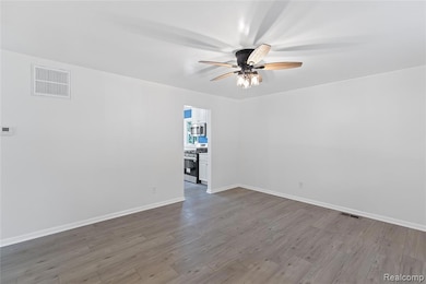Spare room with wood finished floors and ceiling fan