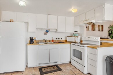 Kitchen with white appliances, under cabinet range