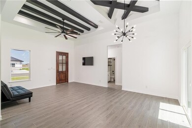 Unfurnished living room featuring beam ceiling, light wood-style flooring, a chandelier, a high ceiling, and a raised ceiling