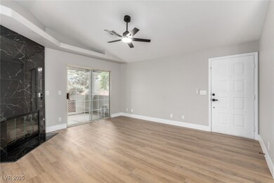 Unfurnished living room with ceiling fan, vaulted