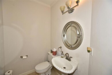 Half bathroom featuring crown molding and a sink