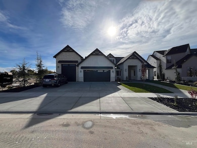 View of front of house featuring stone siding, driveway, and a garage