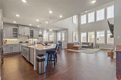 Beautiful open floor plan letting ton of natural light from the wall of windows and double story ceiling
