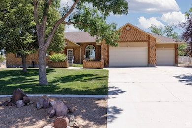 View of front of property with an attached garage, concrete driveway, a front lawn, brick siding, and a shingled roof