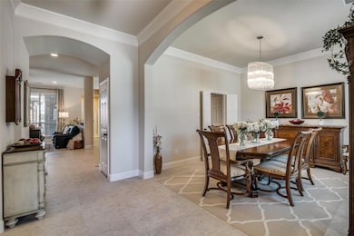 Tiled dining room featuring crown molding and a notable chandelier