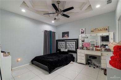 Bedroom with visible vents, coffered ceiling, and light tile patterned floors