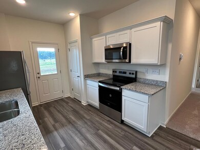 Kitchen featuring stainless steel appliances, dark