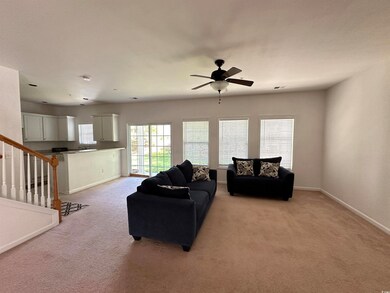 Living room with light colored carpet, baseboards,