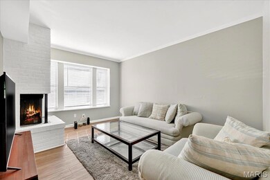 Living room featuring crown molding, a fireplace, and wood finished floors