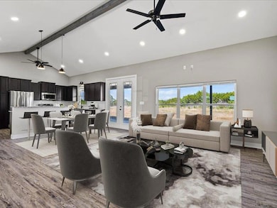 Living room with a ceiling fan, beam ceiling, rec